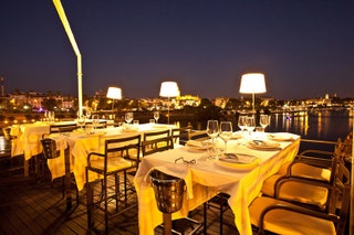 ロマンチックな川沿いの夕食を楽しめるセビリア最高のバー トリアナ橋のたもと、カラフルな家々の近くにあります。